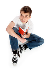 Image showing Pre teen boy sitting with a book