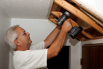 Image showing Senior man fixing stairs