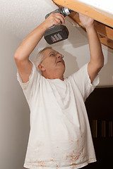 Image showing Senior man drilling