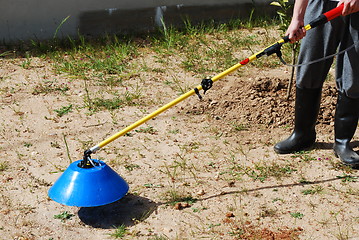 Image showing Young farmer fertilizing the soil