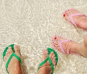 Image showing Colorful flip flops on translucent ocean water