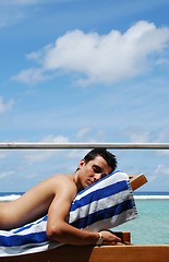 Image showing Young man sunbathing in a Maldives resort room