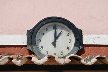 Image showing Ancient clock above roof tiles (1 o'clock)