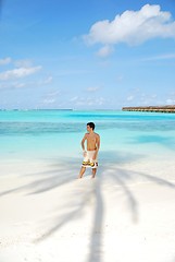 Image showing Young man standing on a tropical beach in Maldives