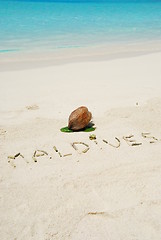 Image showing Maldives written in a sandy tropical beach and coconut fruit