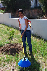 Image showing Young farmer fertilizing the soil