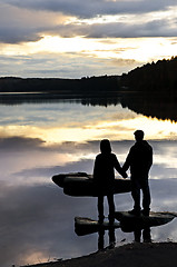 Image showing Silhouette of people watching sunset at lake