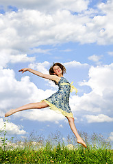 Image showing Young girl jumping in meadow