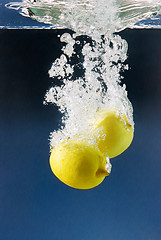 Image showing couple of lemons plunged in blue water