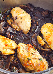 Image showing Chickens and mushrooms cooking vertical