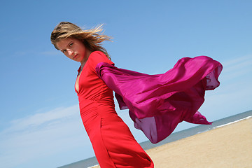 Image showing young women on beach with red fluttering scarf