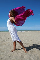 Image showing young women in white on beach with red fluttering scarf