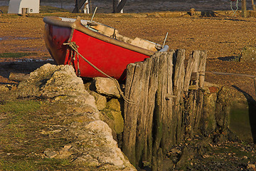 Image showing Red rowing boat berthed on land