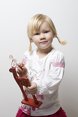 Image showing Little girl holding toy reindeer.