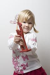 Image showing Little girl holding toy reindeer.