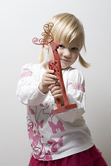 Image showing Little girl holding toy reindeer.