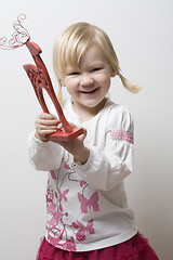 Image showing Happy little girl holding toy reindeer.