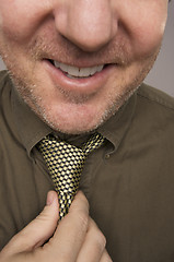 Image showing Smiling Man Fixing Tie