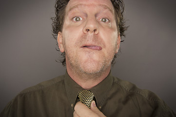 Image showing Man Concentrating Fixing Tie