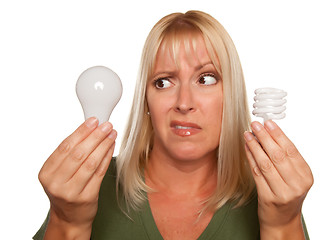 Image showing Funny Woman Holding Energy Saving and Regular Light Bulbs