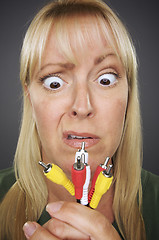 Image showing Confused Woman Holding Electronic Cables