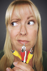 Image showing Confused Woman Holding Electronic Cables