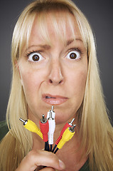 Image showing Confused Woman Holding Electronic Cables