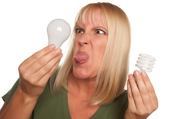 Image showing Funny Woman Holding Energy Saving and Regular Light Bulbs