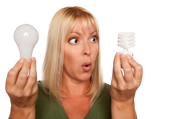 Image showing Funny Woman Holding Energy Saving and Regular Light Bulbs