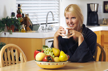 Image showing Woman with Cup of Coffee in Kitchen Smiling