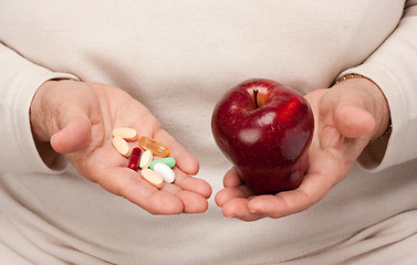 Image showing Senior Woman Holding Pills and Apple