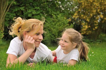 Image showing Young mother and daughter laying on the grass