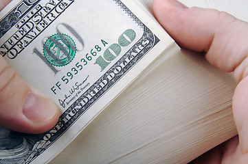 Image showing Man Fanning Large Stack of One Hundred Dollar Dollar Bills