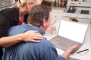 Image showing Couple In Kitchen Using Laptop with Blank Screen