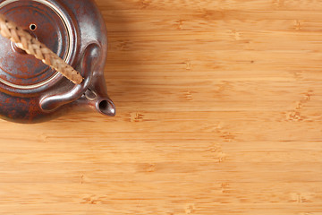 Image showing Tea Pot and Bamboo Textured Surface