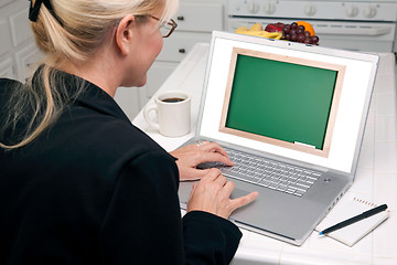 Image showing Woman In Kitchen Using Laptop - Chalkbaord