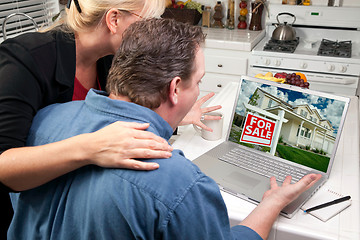 Image showing Couple In Kitchen Using Laptop - Real Estate