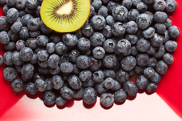 Image showing Macro Kiwi and Blueberries on Red Dish