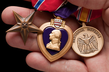 Image showing Man Holding Purple Heart, Bronze and National Defense War Medals