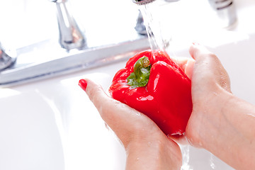 Image showing Woman Washing Red Bell Pepper
