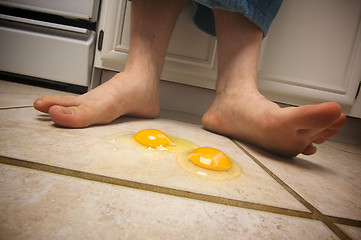 Image showing Eggs on the Floor at Man's Feet