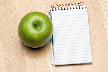 Image showing Pad of Paper and Apple on Wood