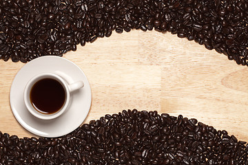 Image showing Dark Roasted Coffee Beans and Cup on Wood Background