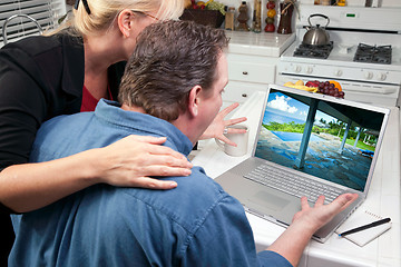 Image showing Couple In Kitchen Using Laptop - Real Estate and Vacations