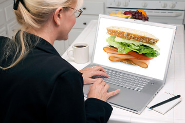 Image showing Woman In Kitchen Using Laptop - Food and Recipes