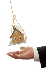 Image showing Businessman's Hand Under Dangling House