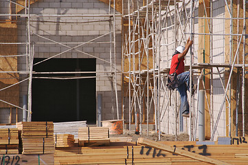 Image showing Carpenter Climbing Down Scaffolding