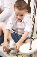 Image showing Adorable Young Boy Getting Socks On