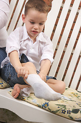 Image showing Adorable Young Boy Getting Socks On