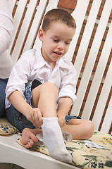 Image showing Adorable Young Boy Getting Socks On